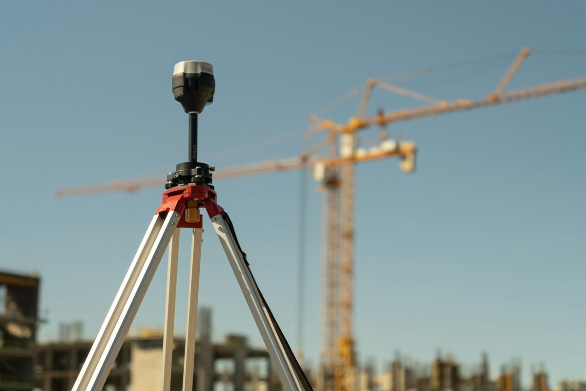 A surveying instrument set up on a construction site at first light